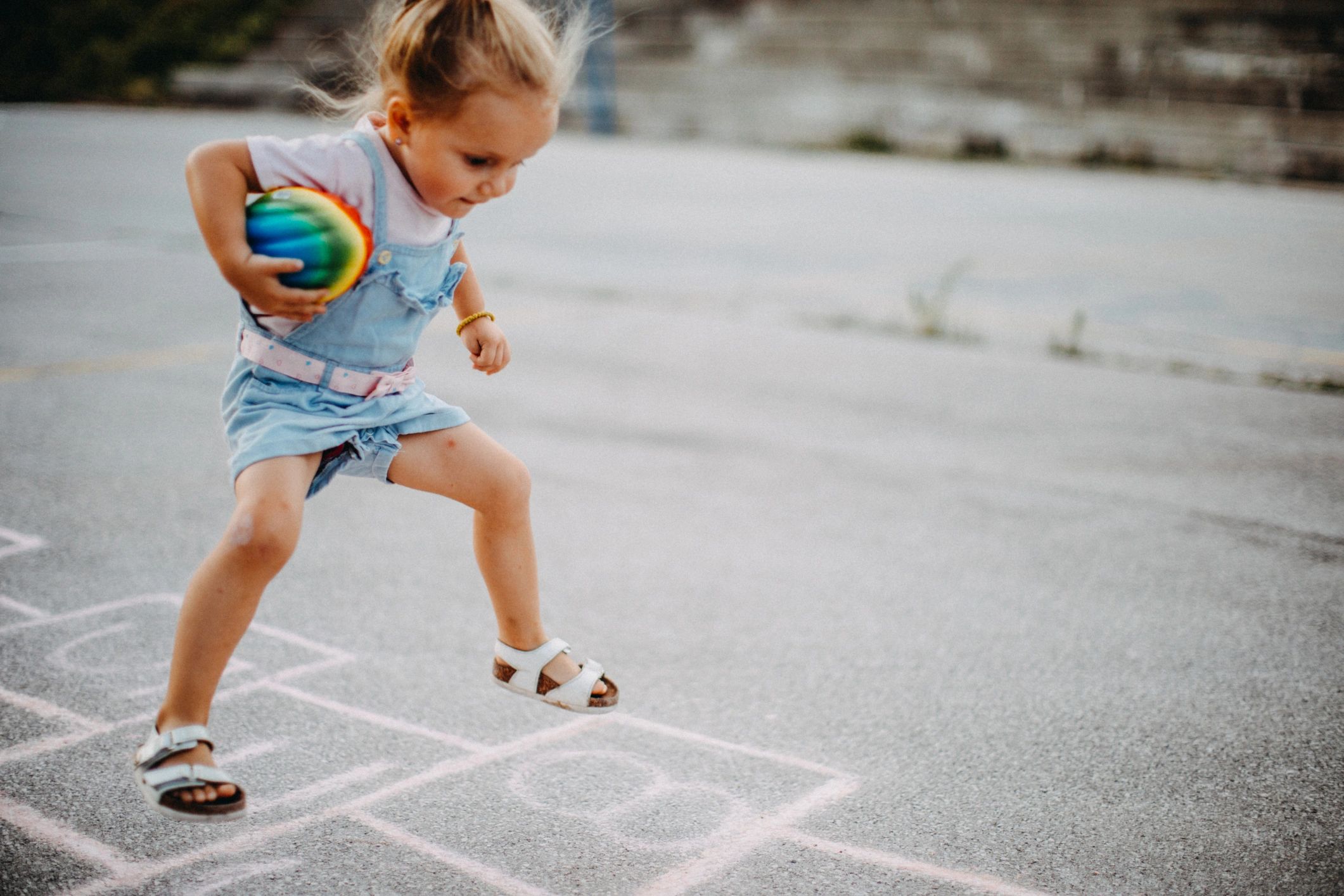 Child jumping while playing hopscotch outdoors