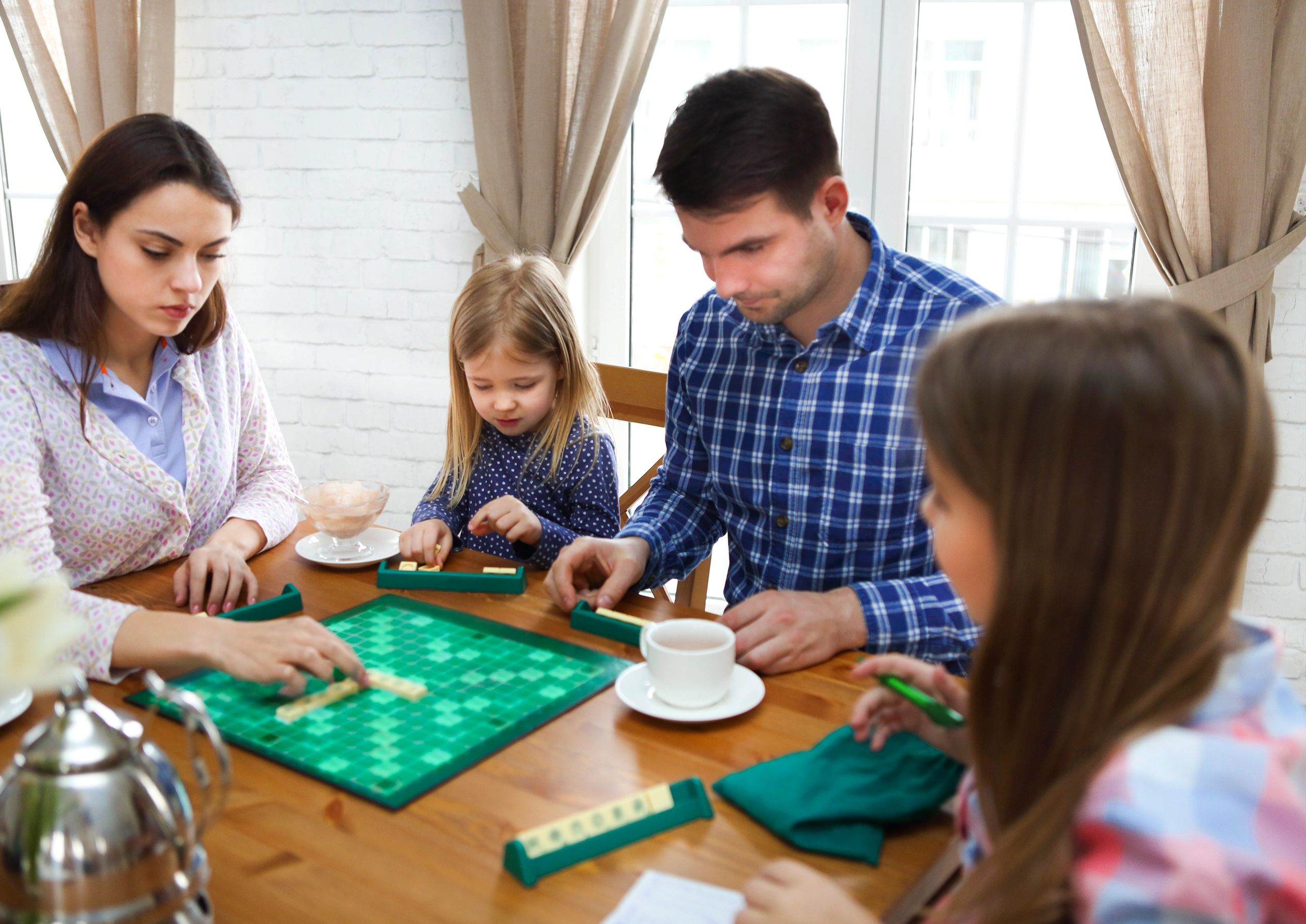 Happy young family playing a board game together at home.