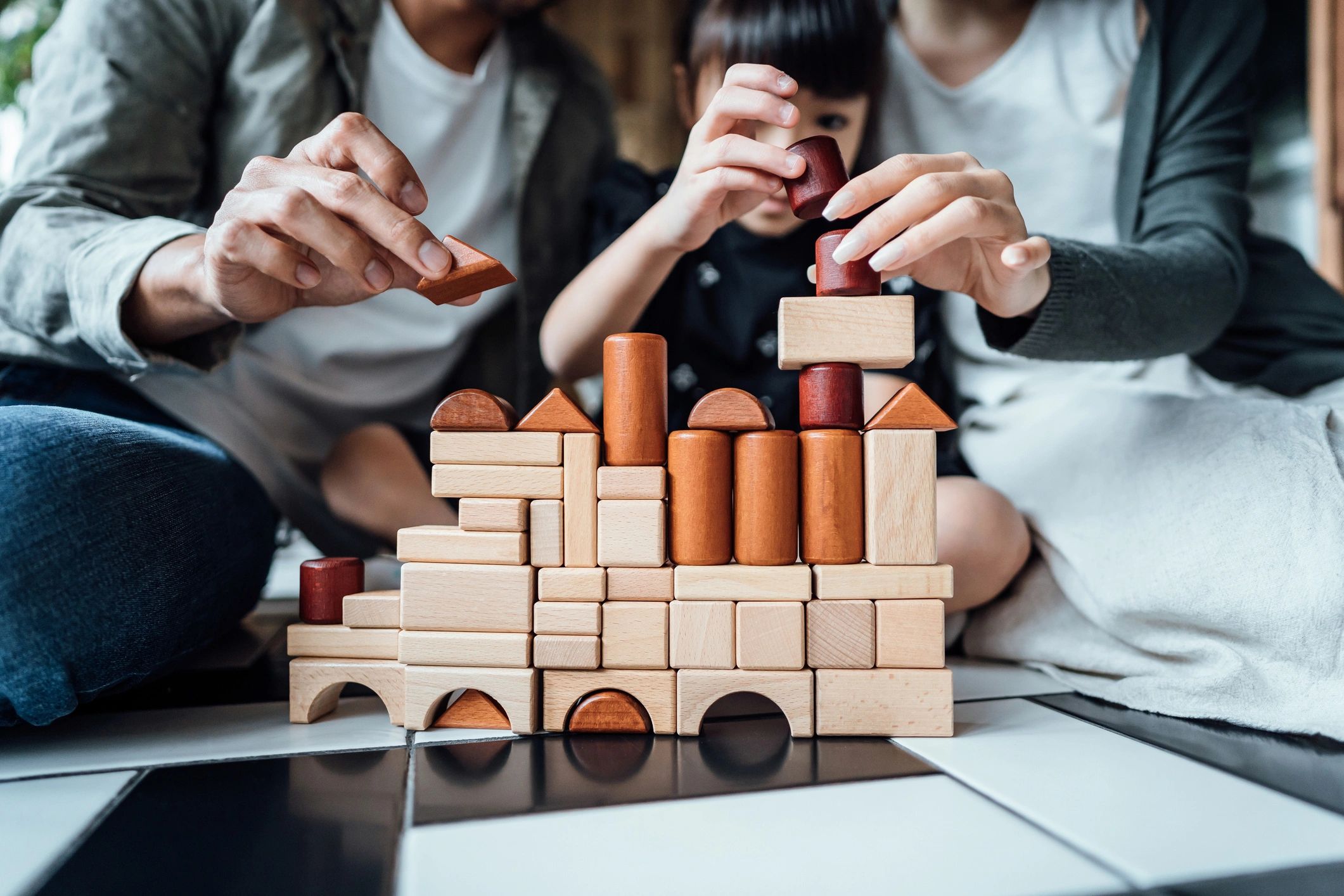 Family playing with wooden blocks on the floor