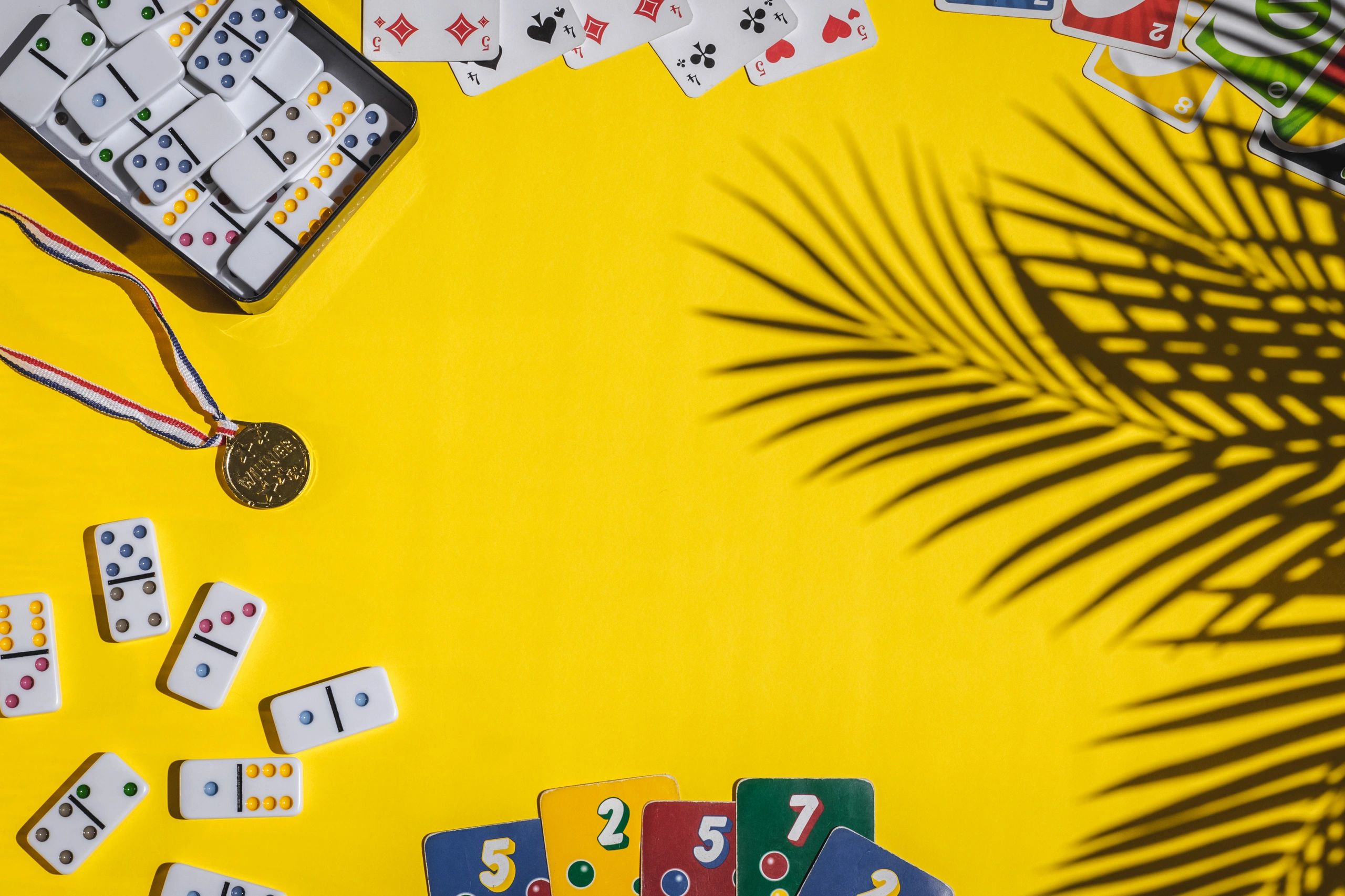 Playing cards and board game pieces arranged in a circle on a yellow background