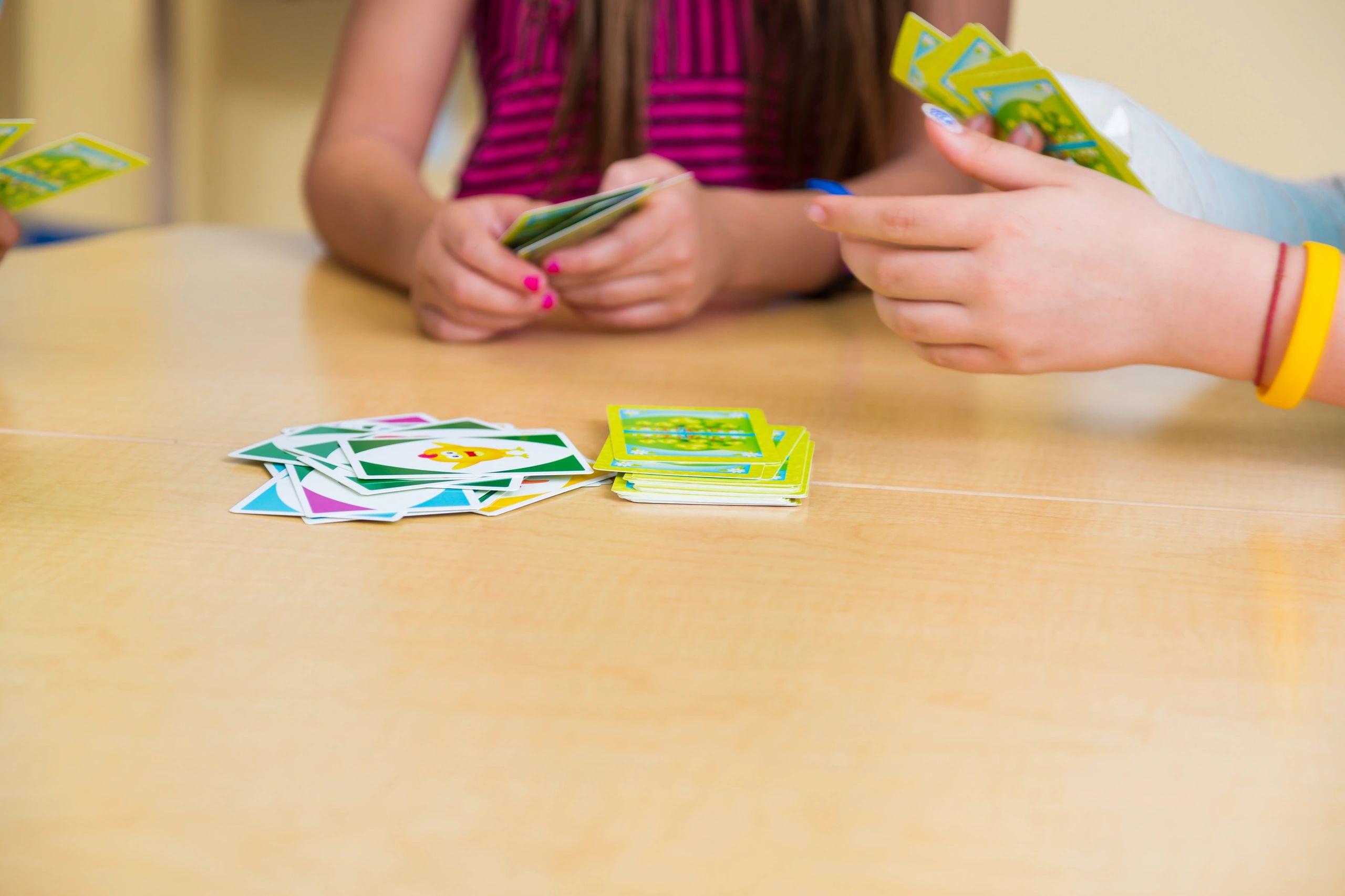 Children playing a card game in a classroom