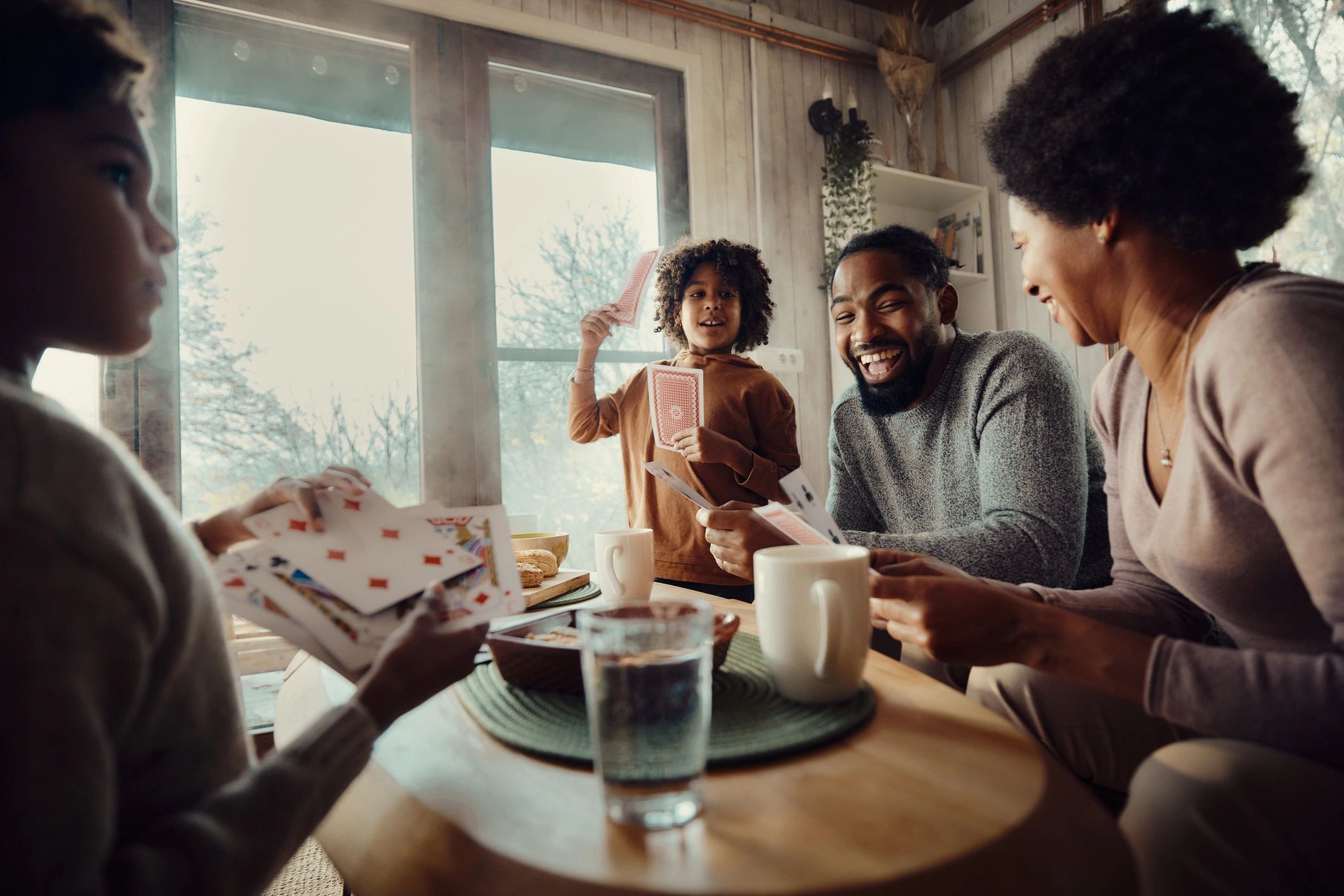 Family playing cards together in a living room