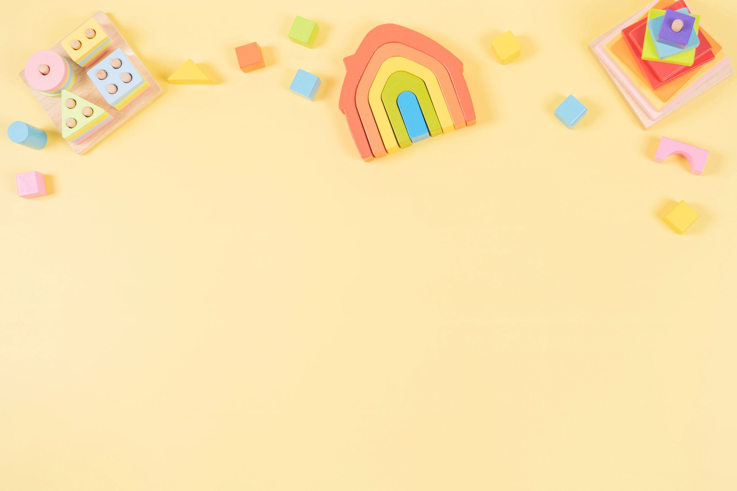 Wooden educational toys on a pastel yellow background