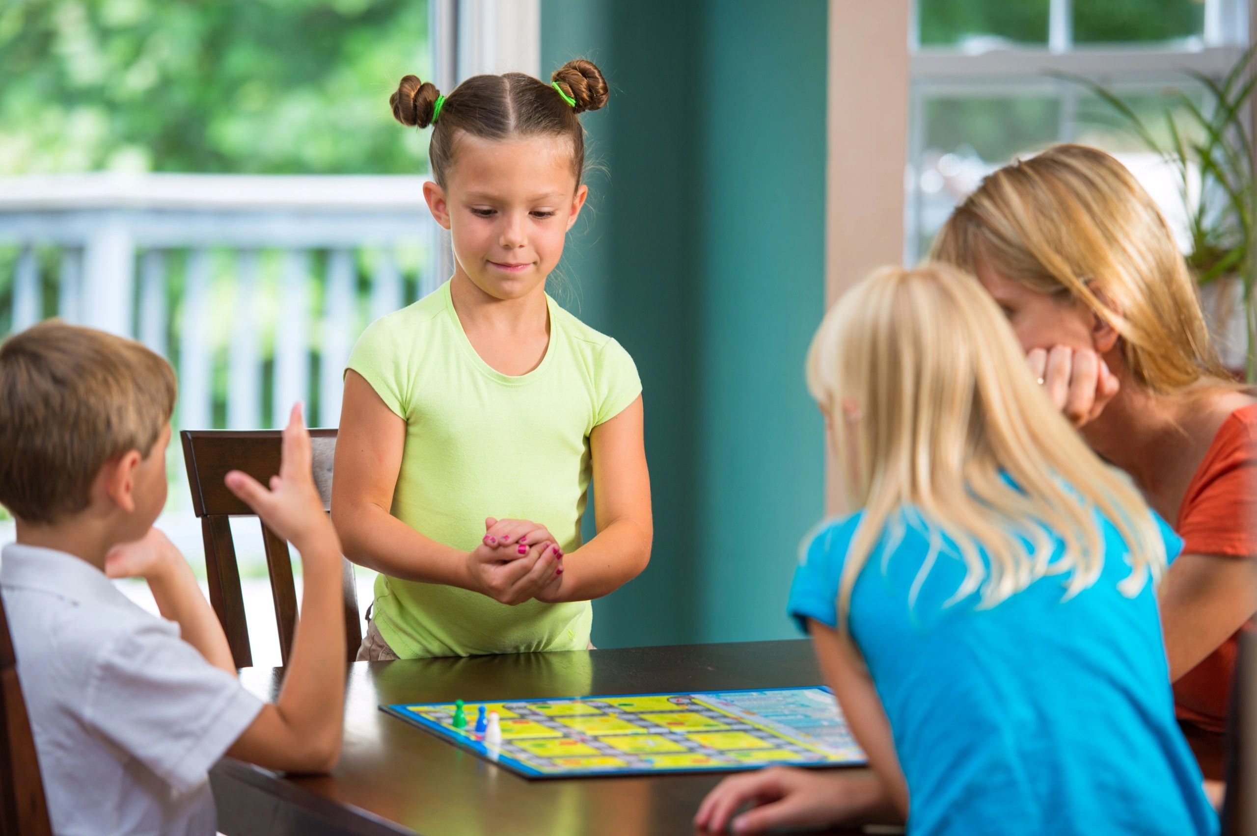 Child playing a board game with family at home