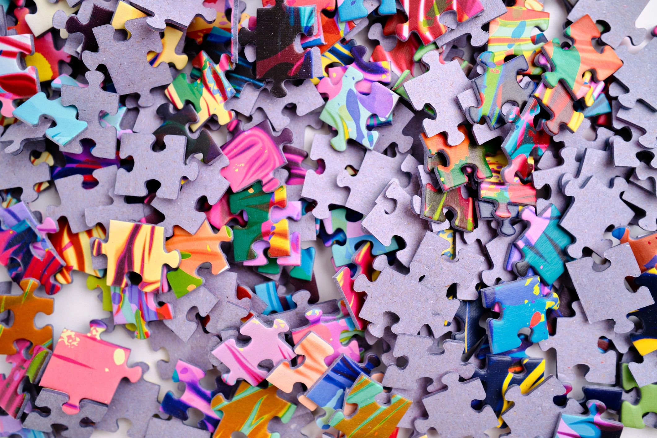 Scattered colorful jigsaw puzzle pieces viewed from above