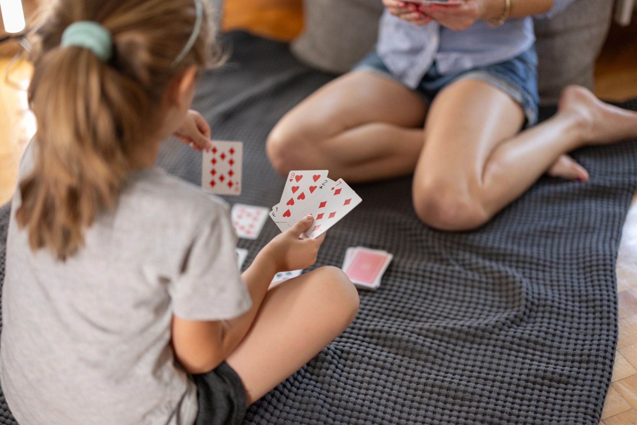 Close-up of a parent and child playing cards together