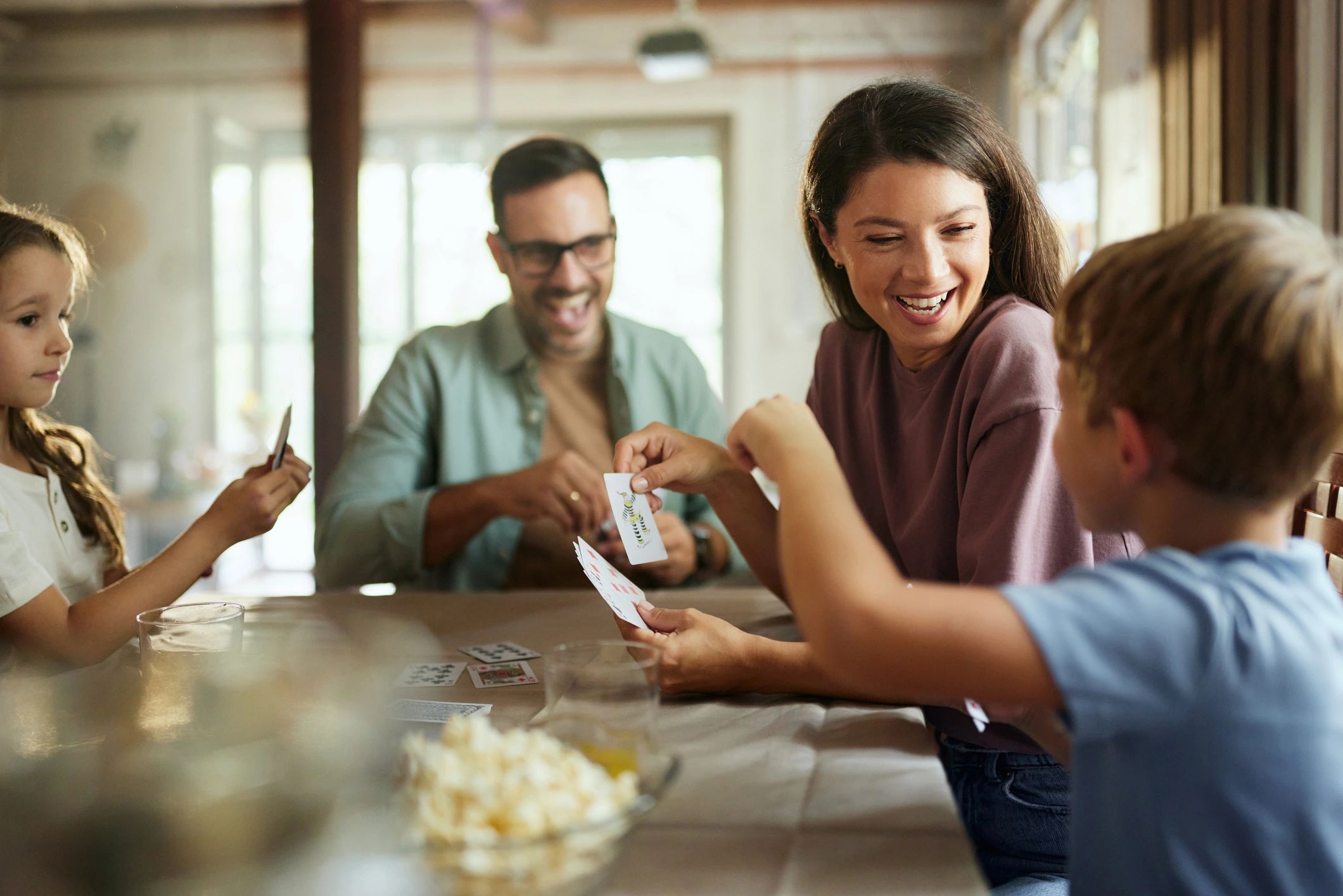 Family gathered at a table playing a card game