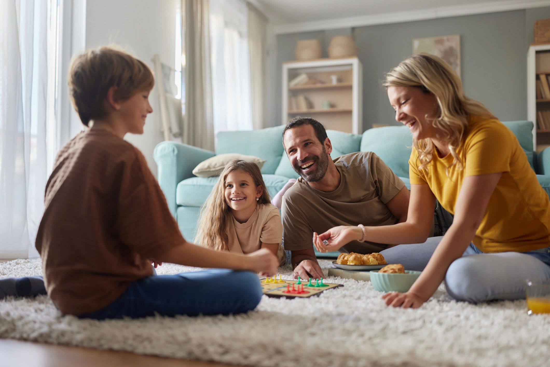 Parents and kids playing a board game together on the floor