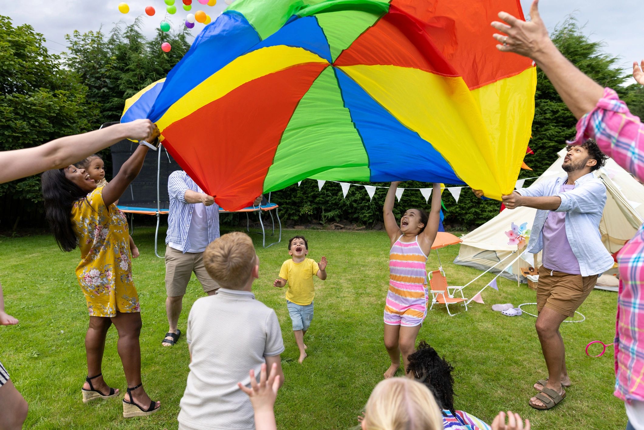 Group of children playing a parachute game outdoors