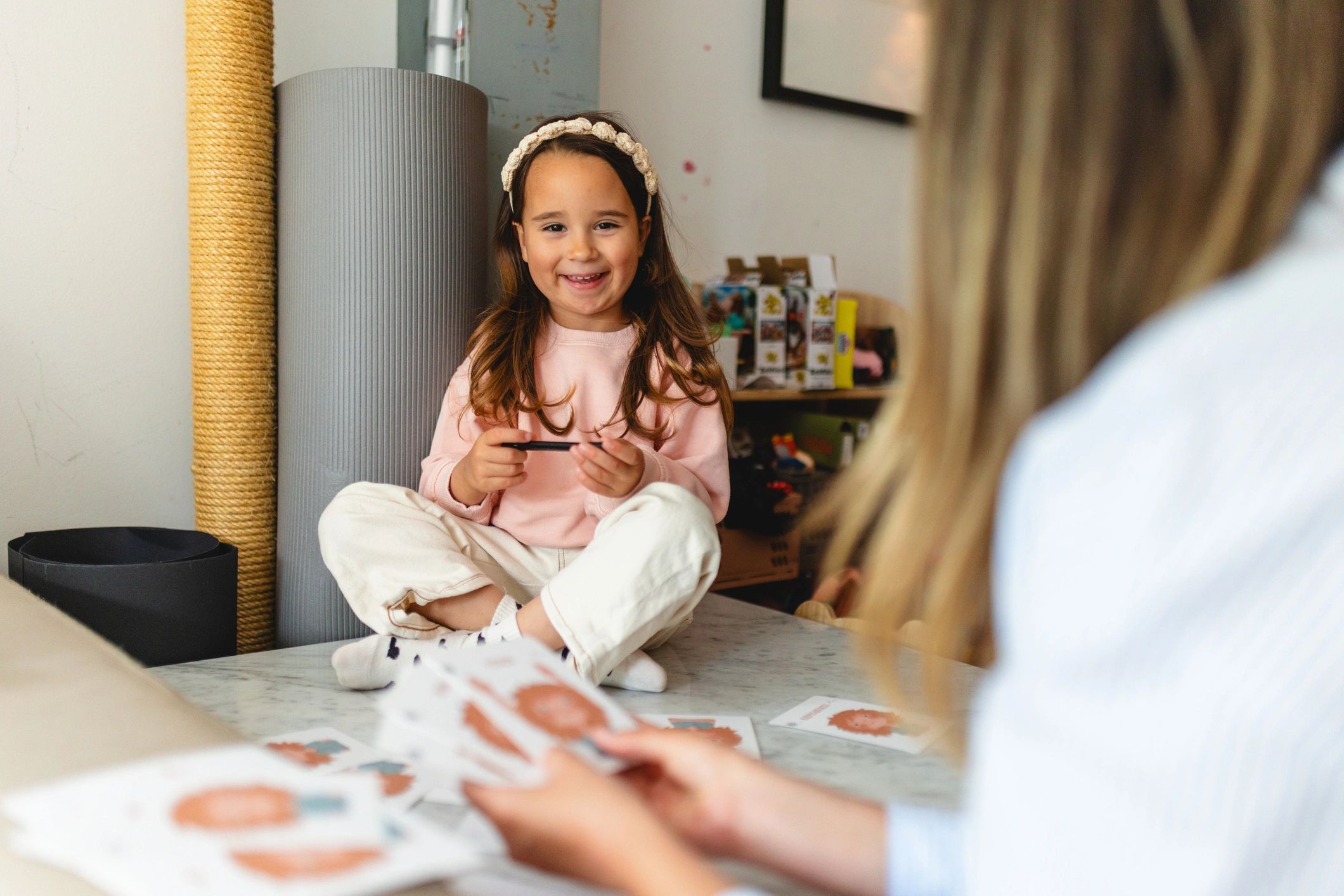 Mother and daughter playing cards together at home