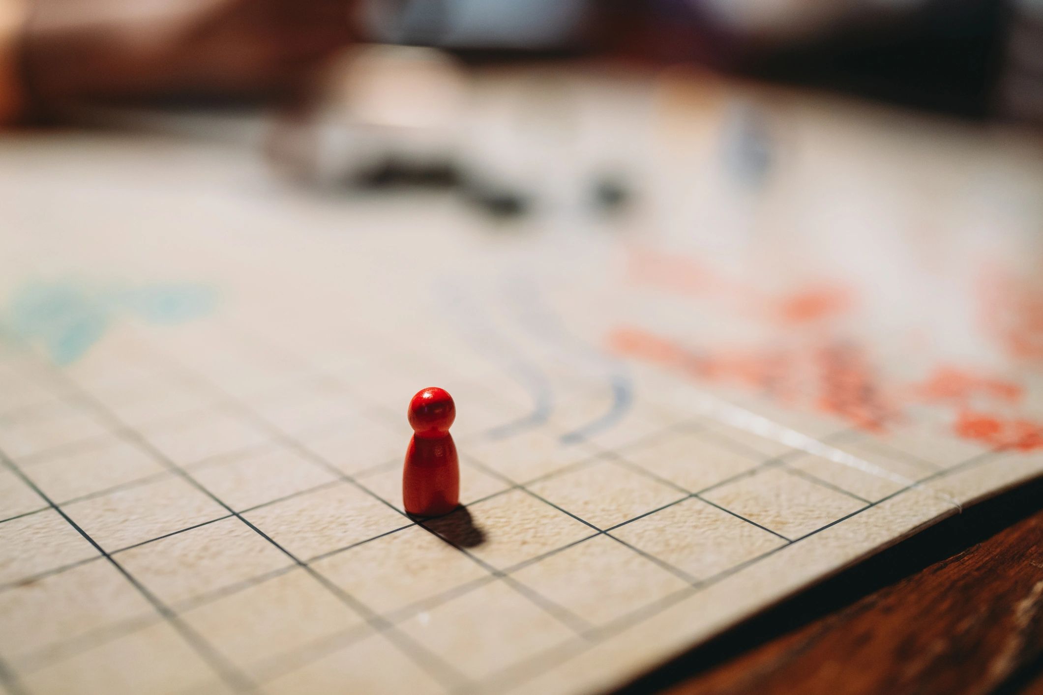 Red pawn game piece on a grid board.